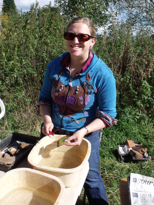 Emily helping the finds team to clean artefacts and enjoying the sun.