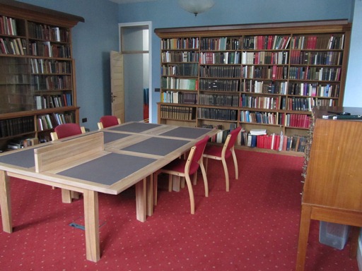 A room with desks, chairs and bookshelves