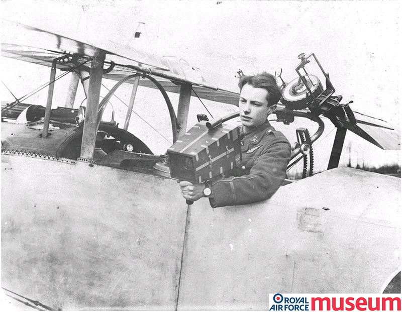 Lieutenant S C Thynne demonstrates the use of a hand-held camera in the back seat of a Nieuport aircraft. Image used with permission of the Trustees of the Royal Air Force Museum.