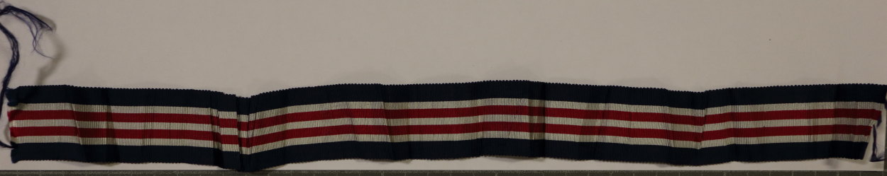 Photo of the sample fabric, a ribbon with blue, white and red stripes as specified in the design, approximately 30 cm (1 ft) long, somewhat frayed at either end