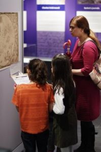 An image which shows a family looking at a map pinned up on a wall.