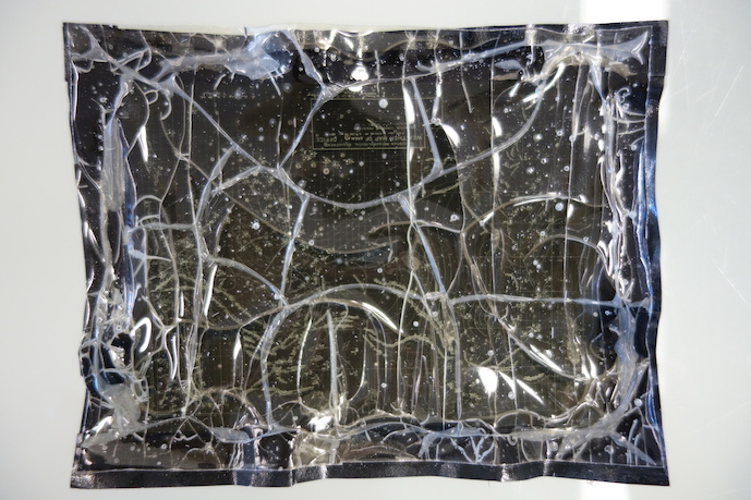 Image of a distorted sheet of cellulose acetate film, with blisters and channels.