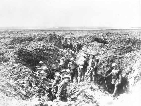 A black-and-white photograph of a group of soldiers working on an earthen trench, digging and consolidating their position.