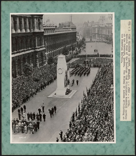 A black-and-white photograph of a large crowd lined on the sidewalk of street while a cenotaph ceremony is taking place in the centre with soldiers in formation in front of a large white cenotaph.