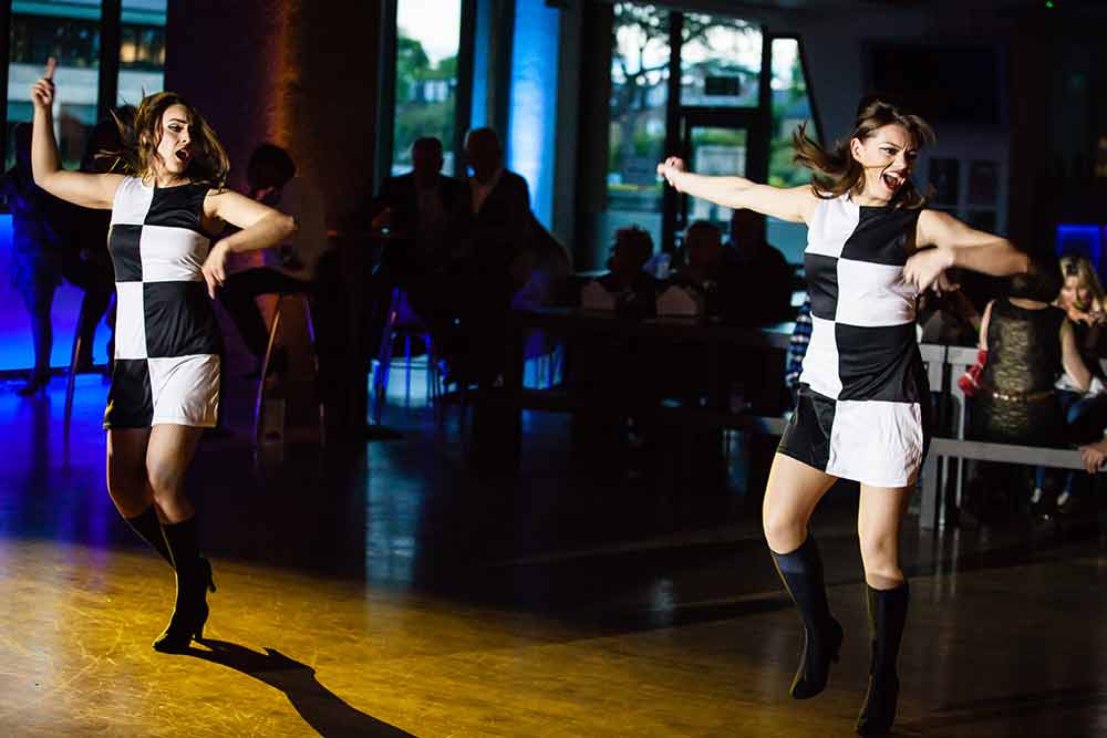 Two dancers in black and white chequered mini-dresses 