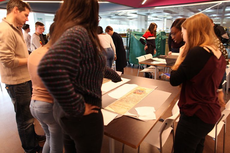 The visiting students look at original documents