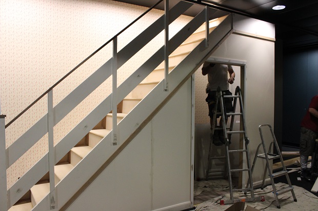 This photograph shows the 'inner refuge' under the stairs, as proposed in the Government's advice leaflet 'Protect and Survive' under construction. A person is standing on a set of steps within it, carrying out decoration.