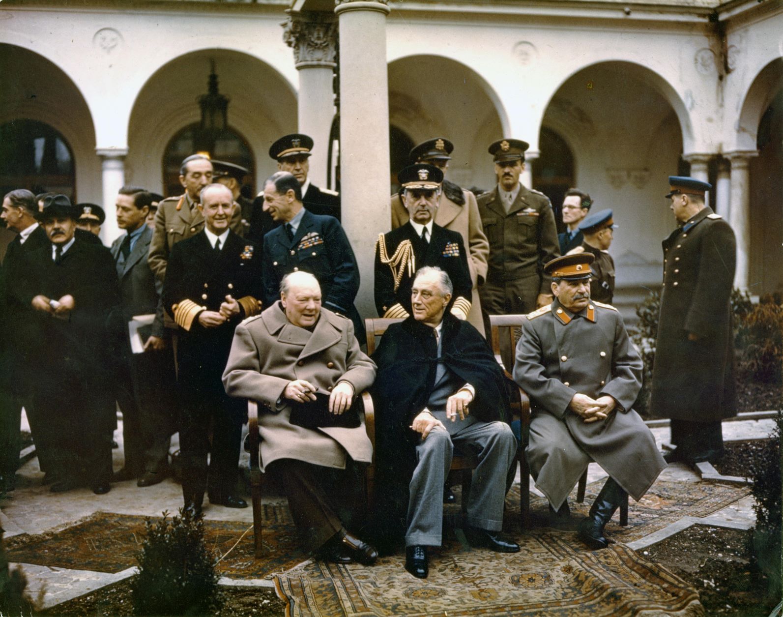 Photograph of the 'Big Three' at Yalta; British Prime Minister Winston Churchill, U.S. President Franklin D. Roosevelt and Soviet Premier Marshal Josef Stalin, flanked by their respective military chiefs and political advisors, at the Livadia Palace during the Yalta Conference, 4 February 1945.