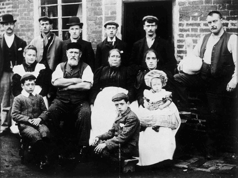 Black and white photograph of thirteen members of the Lowe family during the Victorian era.