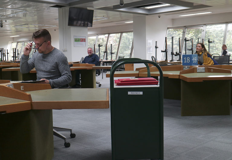 Tables in the reading room with generous spacing in between.