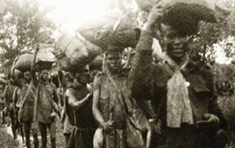 Photograph of African porters taking supplies to the front in the East African Campaign during the First World War.