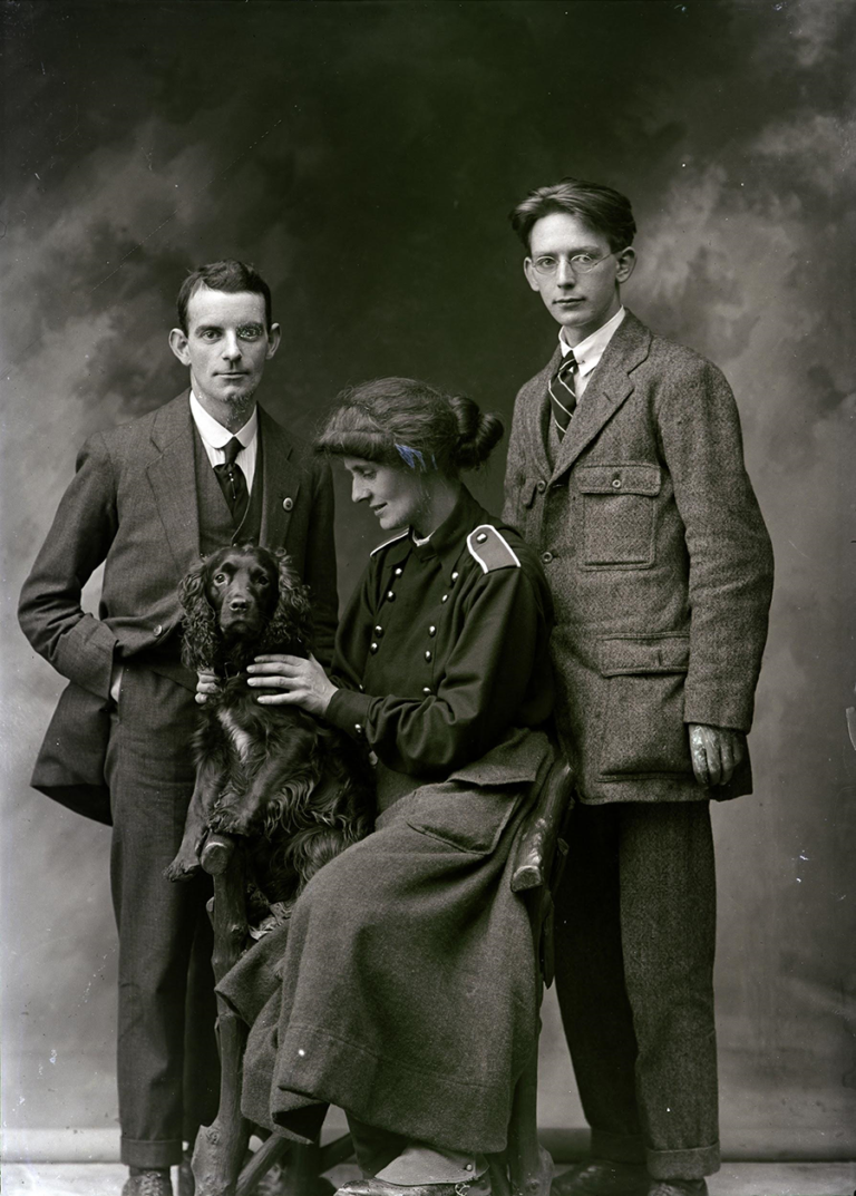 A posed photograph with The Countess surrounded by two senior Fianna officers as she holds her dog Poppet.