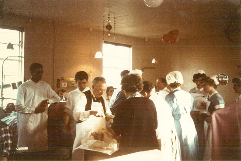 Photo of Ludwig Guttmann operating at the National Spinal Injuries Centre, Stoke Mandeville Hospital, circa 1970s. Credit: Buckinghamshire Archives and the International Wheelchair and Amputee Sports Federation. (He’s not operating on a person, but a turkey at a Spinal Unit Christmas party).