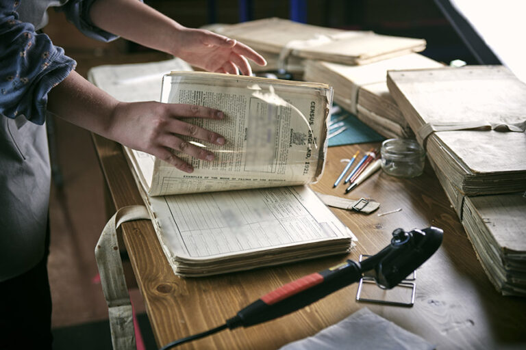 An archivist is at work with an old census book.