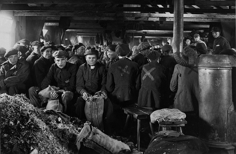 Black and white photograph of prisoners working in a factory.