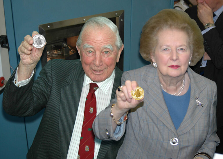 Sir Rex Hunt alongside Margaret Thatcher holding up an official coin.