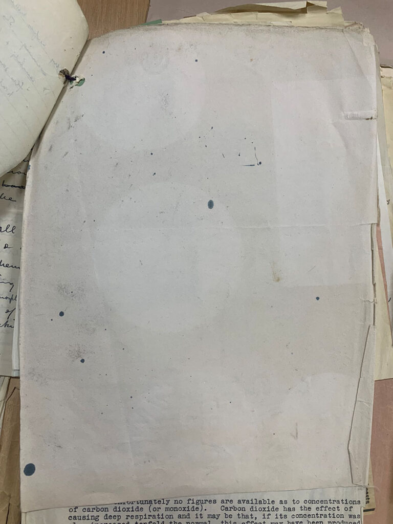 A piece of blotting paper with a few scattered ink blots and larger white circular outlines.