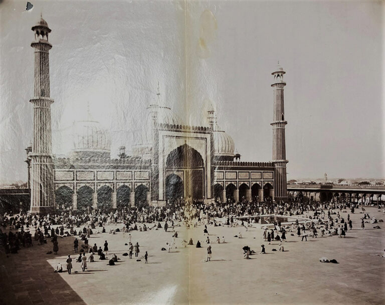 Large crowds of people stand in front of the imposing building of the Jama Masjid at Delhi.