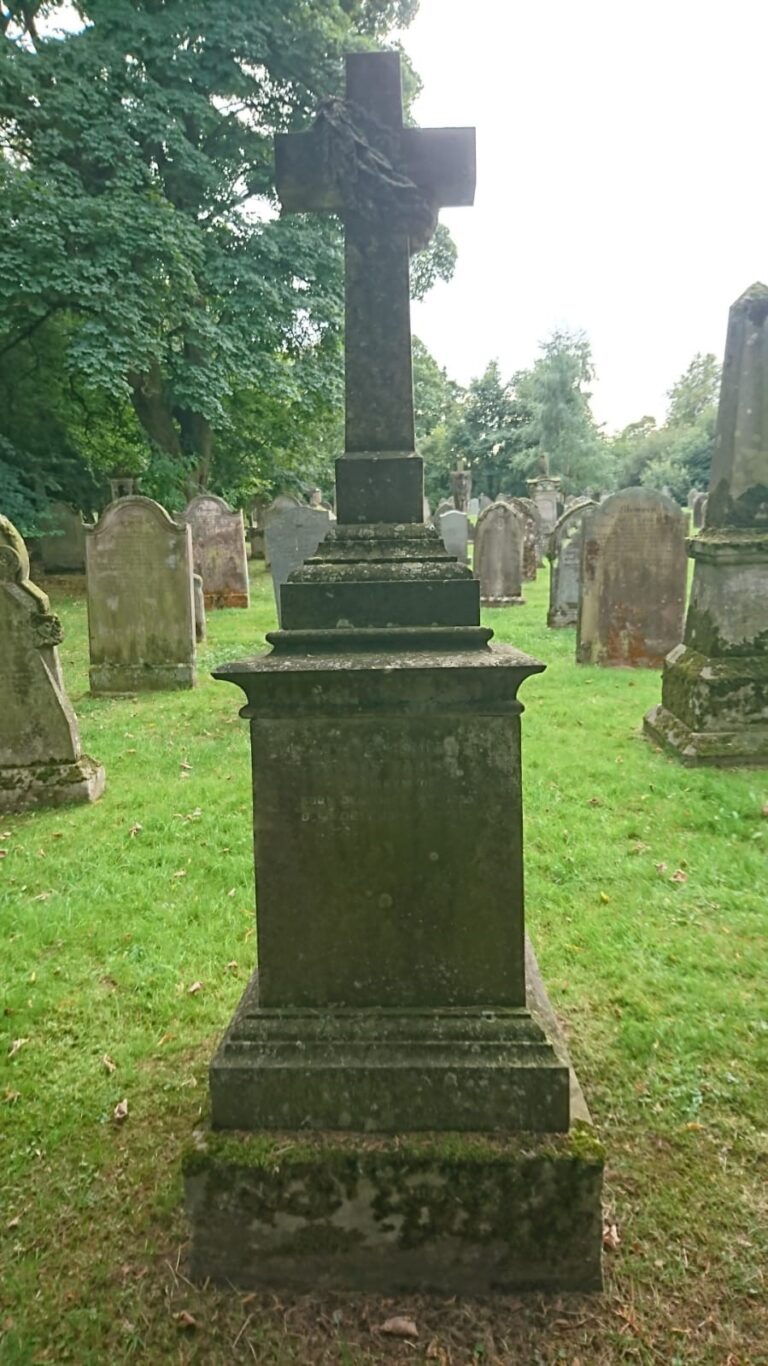 Gravestone with a cross in a village cemetery.