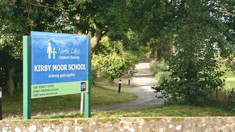 A large sign for Kirby Moor School at the start of the long drive up towards the house.