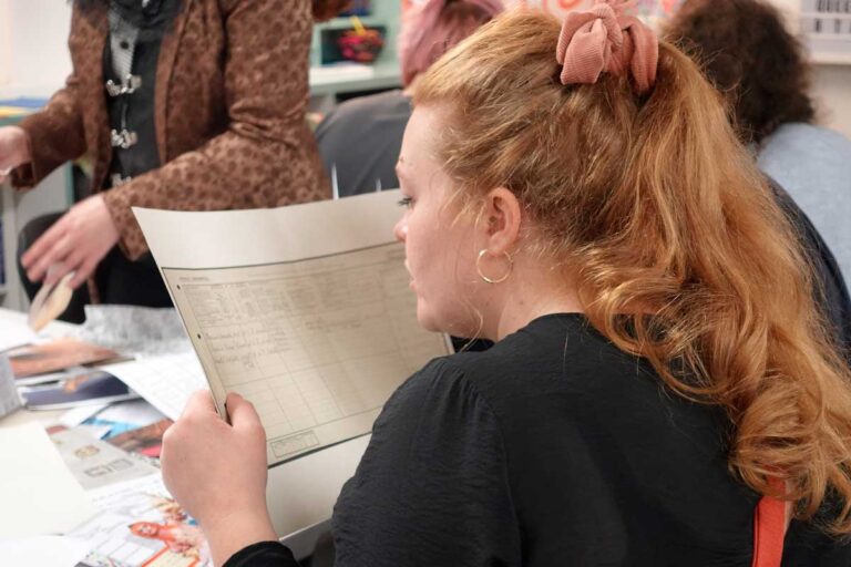 A participant holds a printout of a census up close so they can read it.