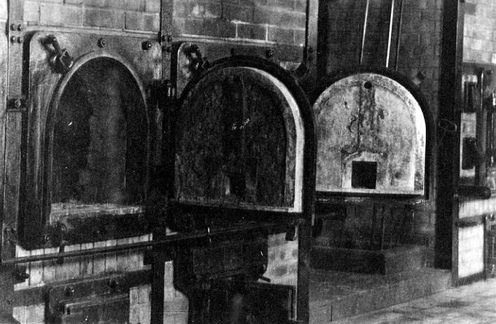 Two large metal ovens set into brickwork, with their doors open.