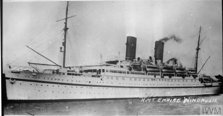 Photograph of a long, white ship with two funnels.