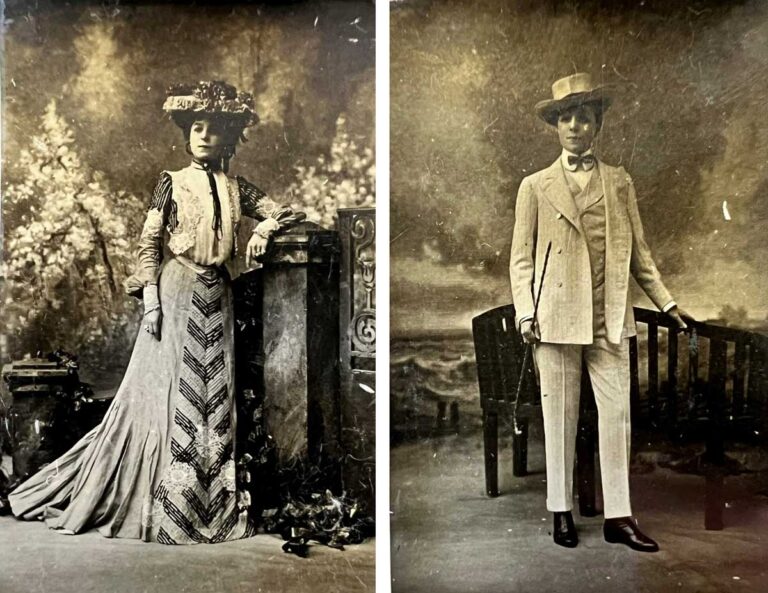 A woman in a dress and lowered hat on the left, and wearing a suit, bowtie and hat on the right.
