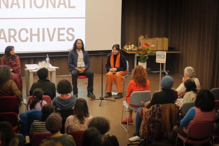 A talk at The National Archives, two people seated in front of a full audience.