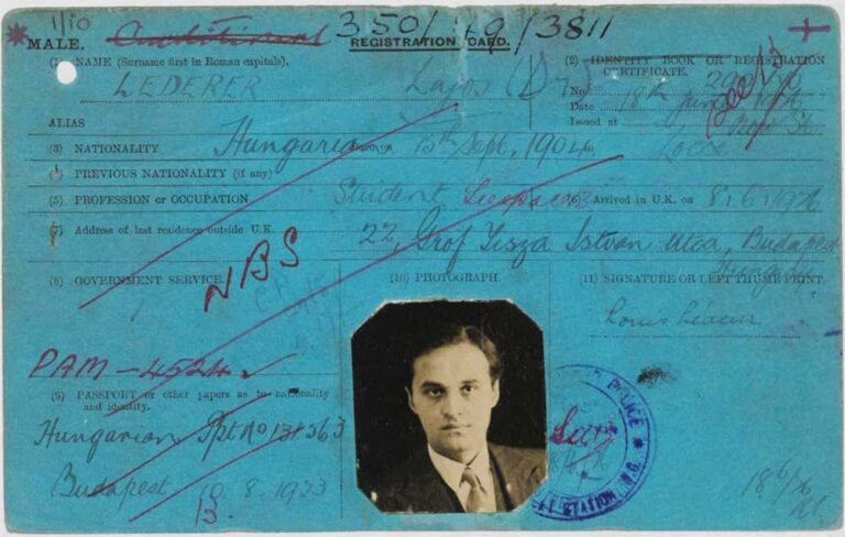 A blue registration card covered in writing. At the bottom is a black and white photo of a young man in a suit and tie