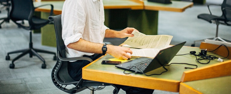 Someone in The National Archives' Reading Room handling a document.