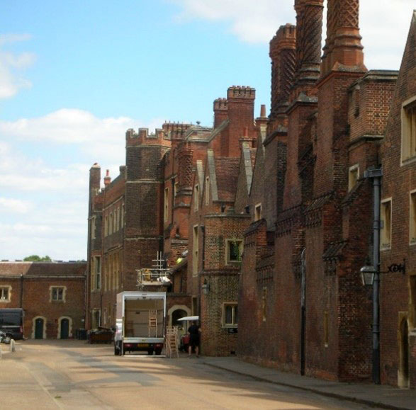 A row of ornate red-brick buildings with a van parked outside.