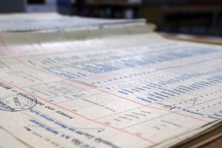 Angled photo of an official document covered in pink lines and blue ink.