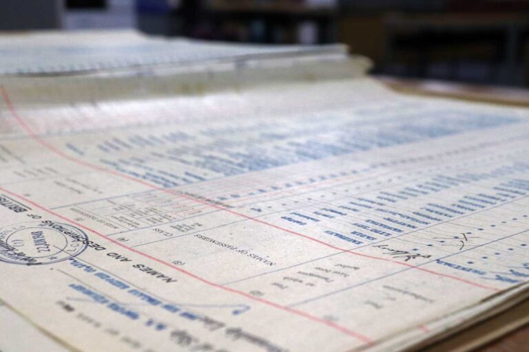 Side-on view of an official document covered in pink lines and blue ink.