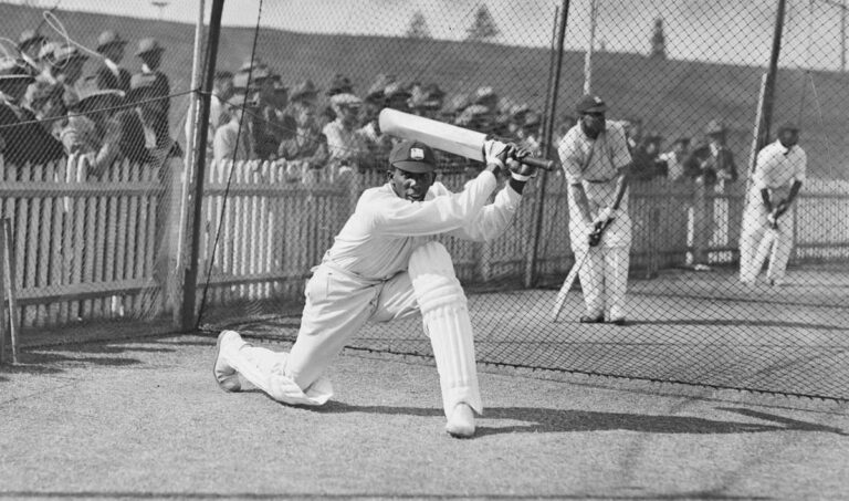 A batsman in cricket whites ready to swing.