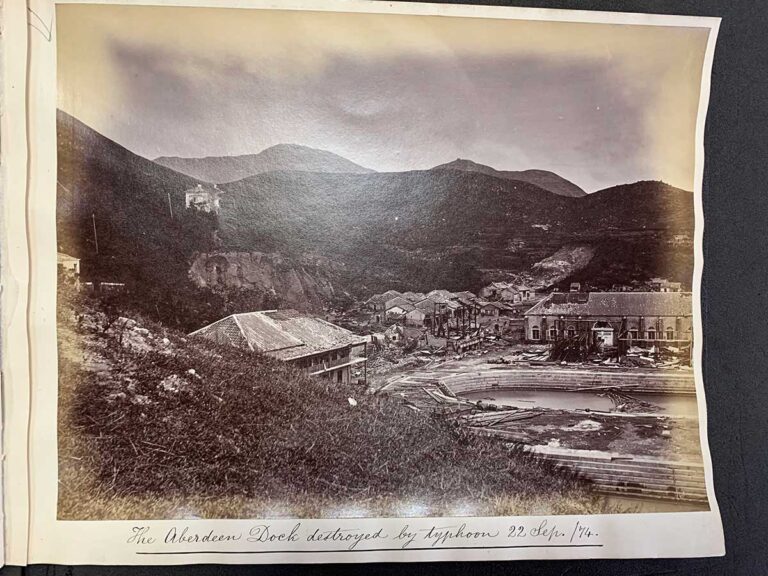 A photo of two large buildings surrounded by hills and debris from fallen constructions.