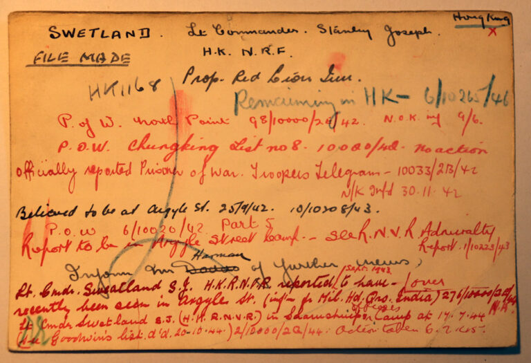 An index card with handwritten notes on it. The notes are written at different times and in different colours: red, black and green. There are dates and the name Swetland written. 