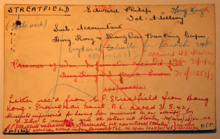 An index card with handwritten notes on it. The notes are written at different times and in different colours: red, black and green. There are dates and the name Streatfield written. 