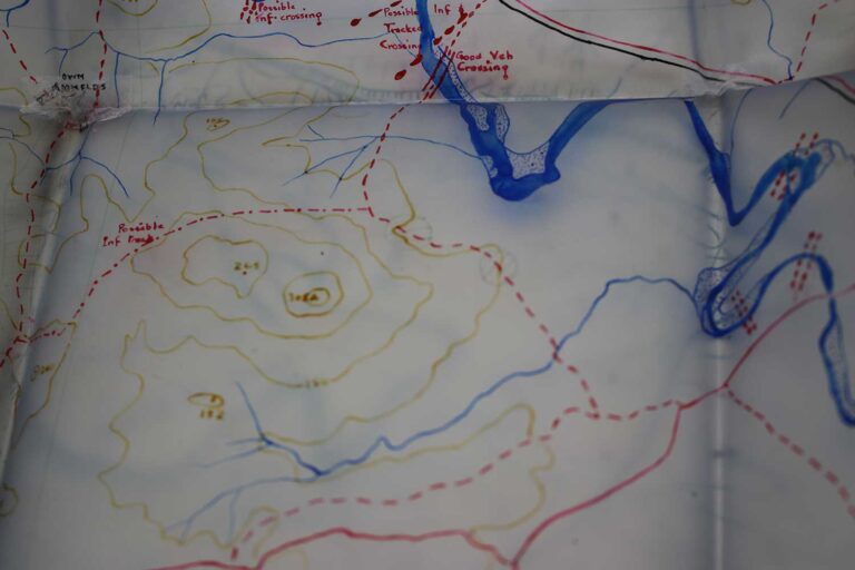 A Second World War map of an area of battle showing blue, yellow and red lines indicating different types of terrain. 