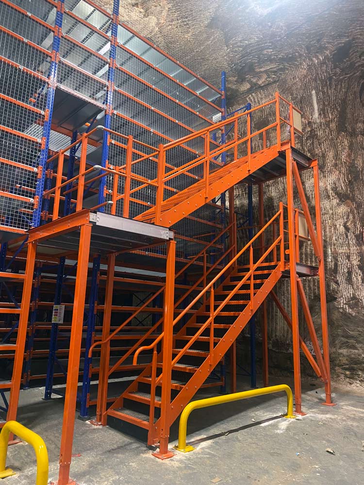 Inside the DeepStore document storage facility showing a staircase with access to three levels of storage racks. 