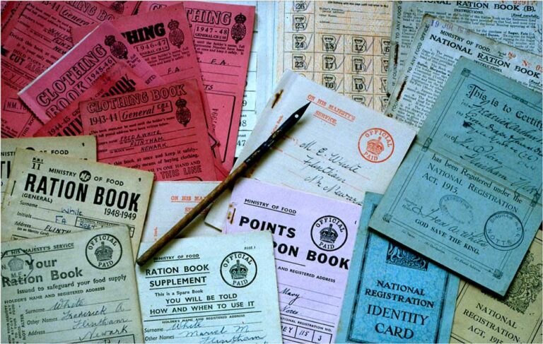 Dozens of different styles of ration book in a pile, ranging from bright red and blue to purple.